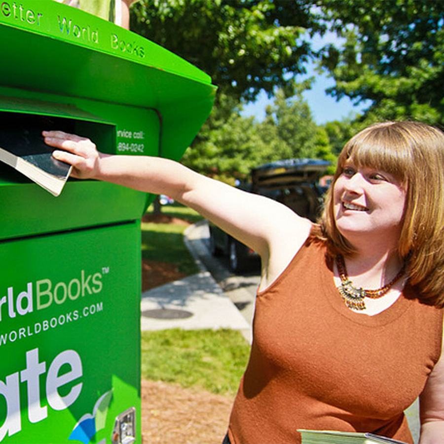 women donating a book to the Better World Books donation box.