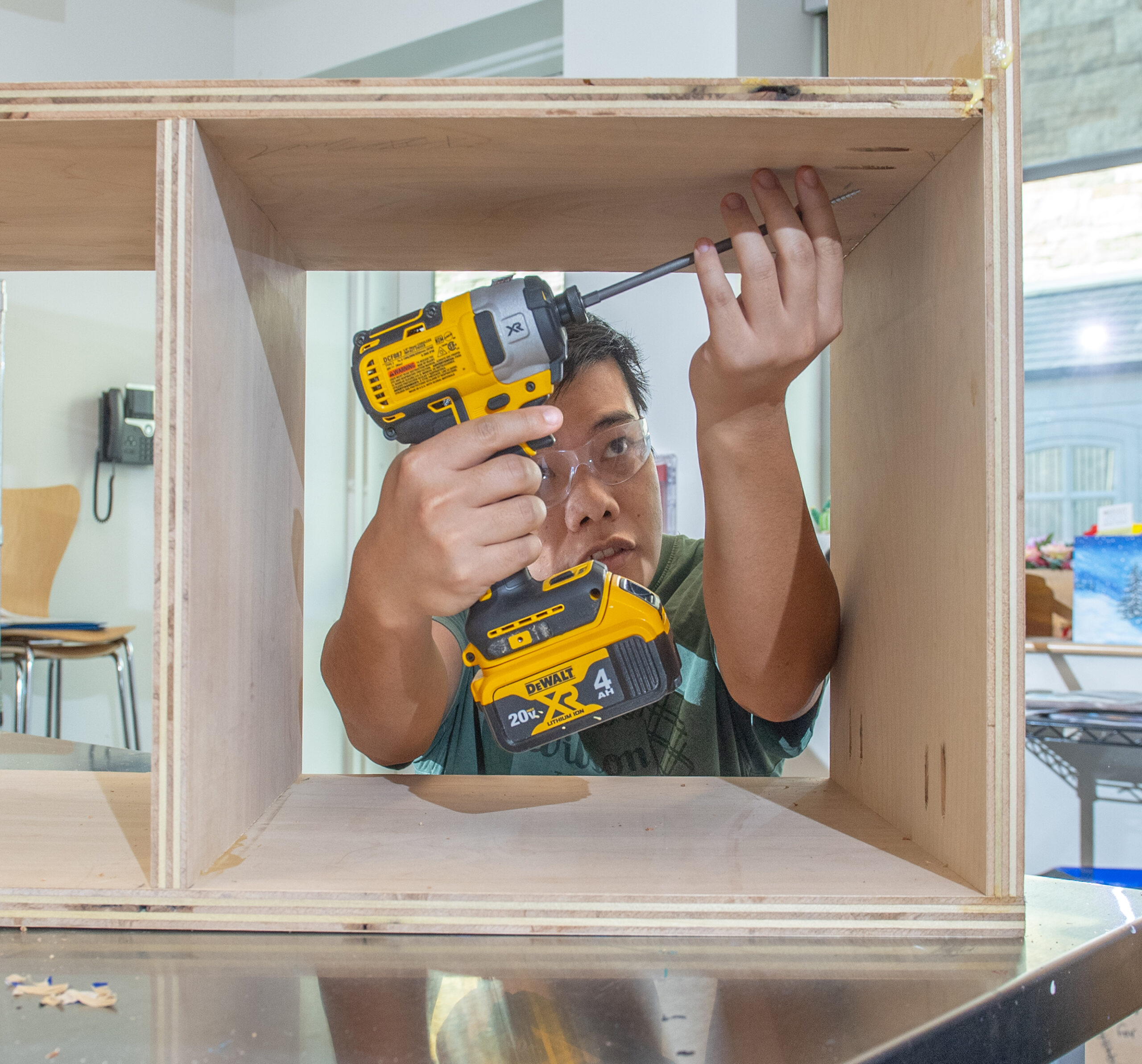 teen learning how to use power tools at a free library DIY center class.