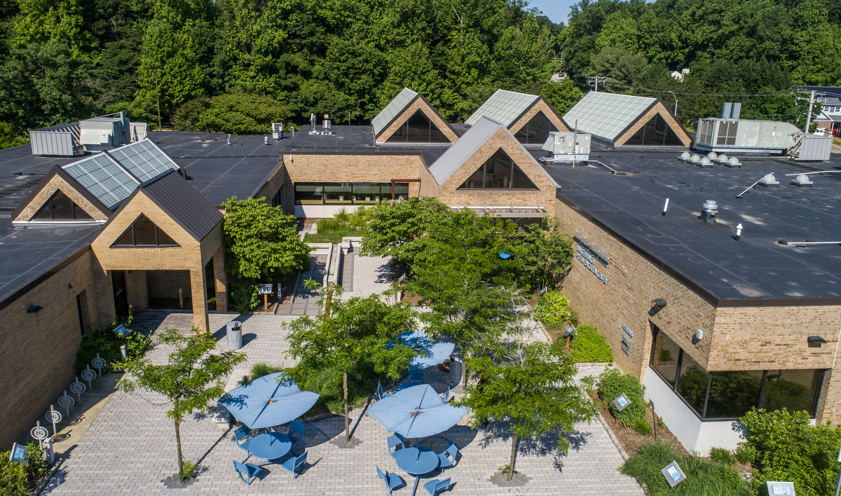 Savage Library exterior with outdoor garden and tables.