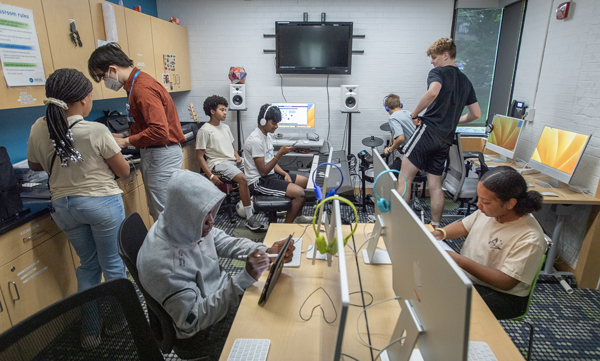 Teenagers recording music in studio.