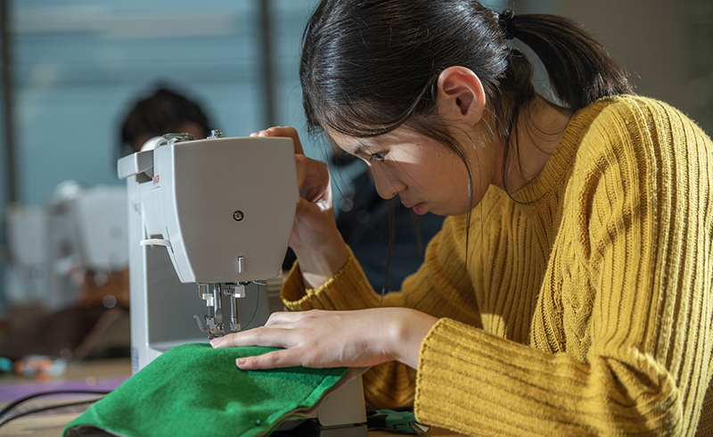 An Adult sewing.