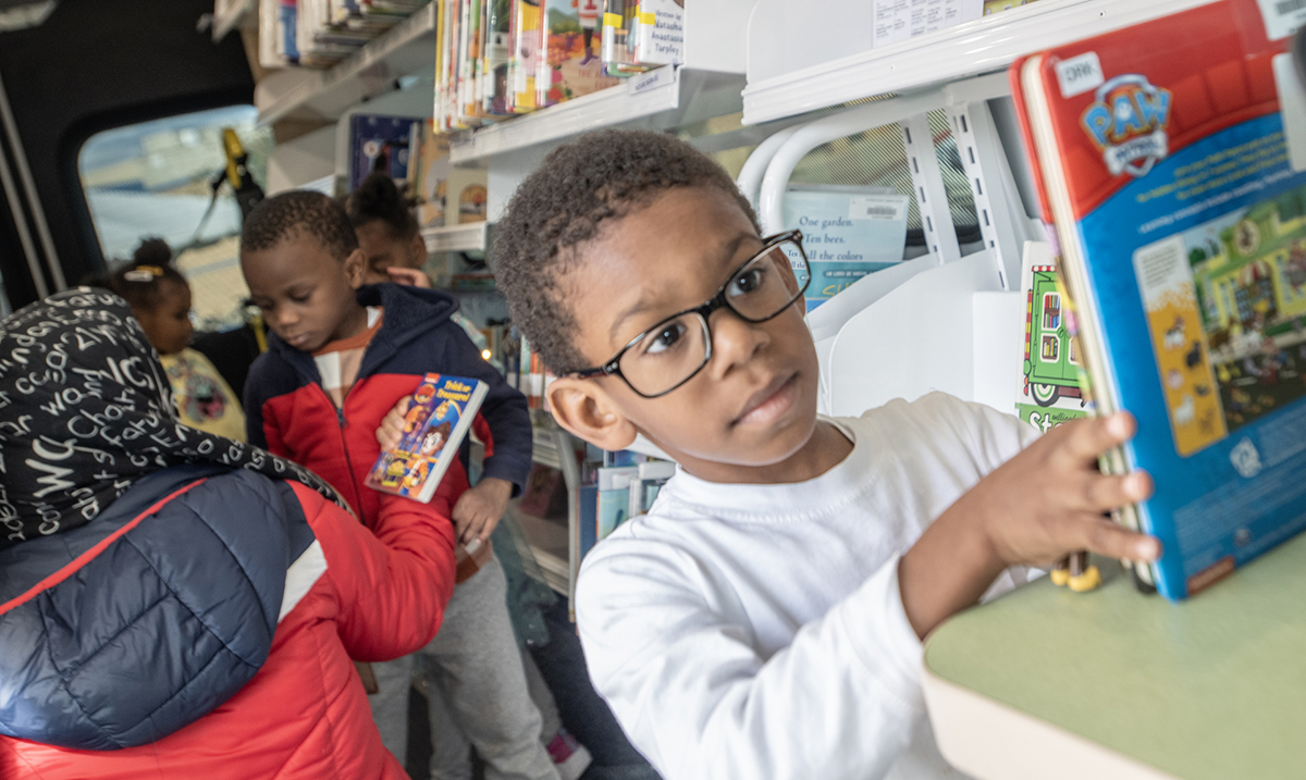 Child in glasses exploring the Library's mobile unit.