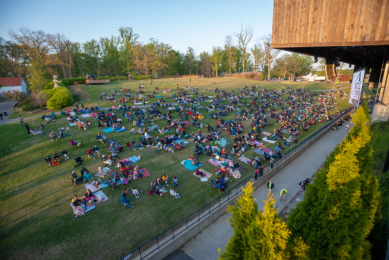 Parent and families picnicking on lawn.