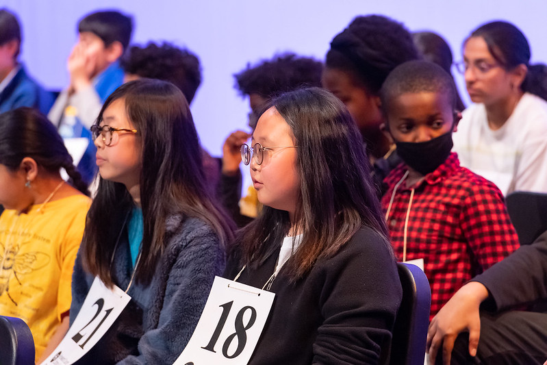 Contestants waiting in chairs.
