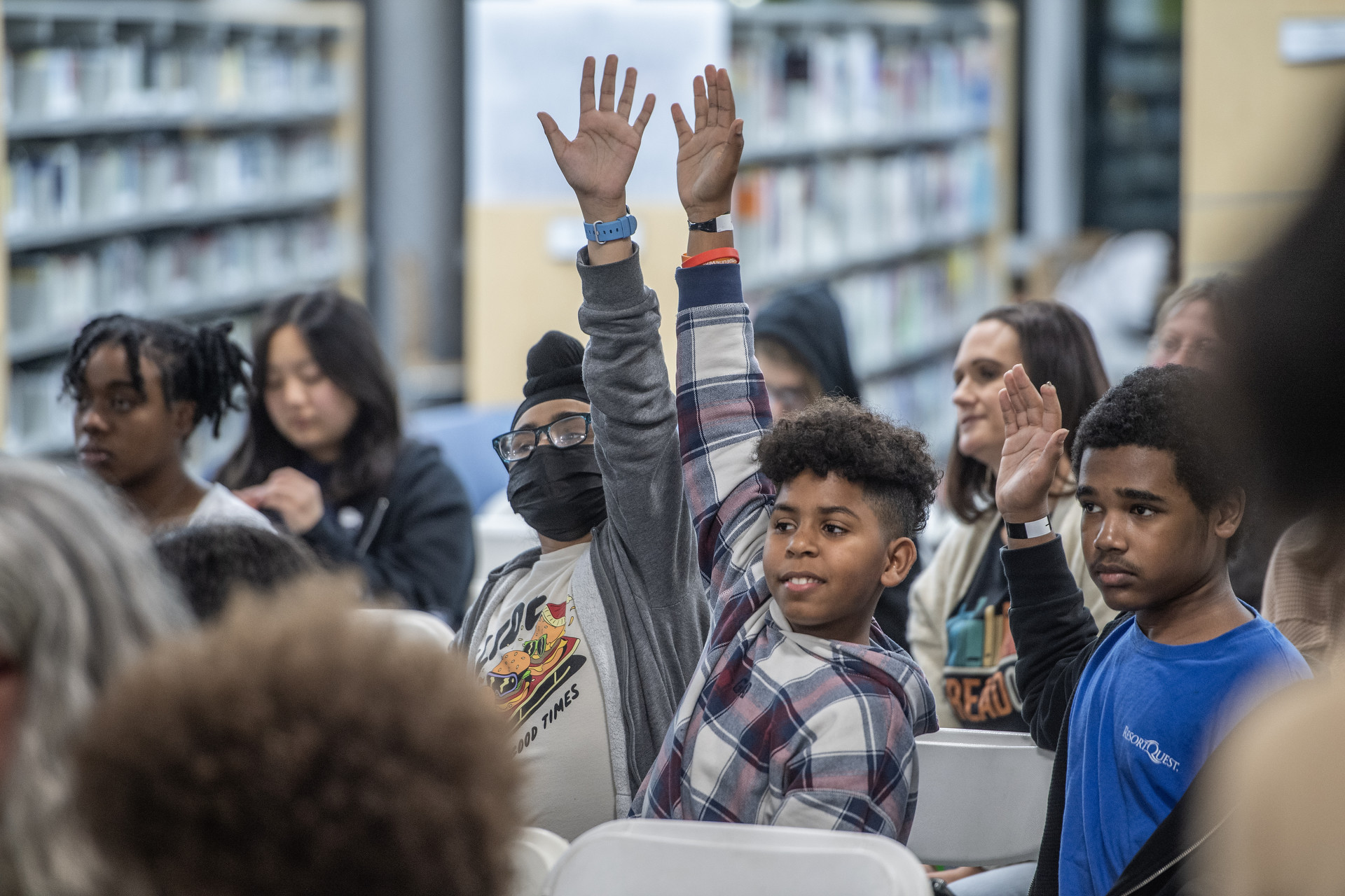 Teenagers excitedly raising there hands.