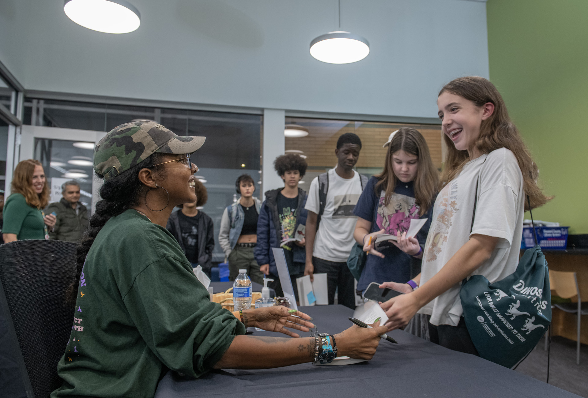 Smiling girl getting a book signed.