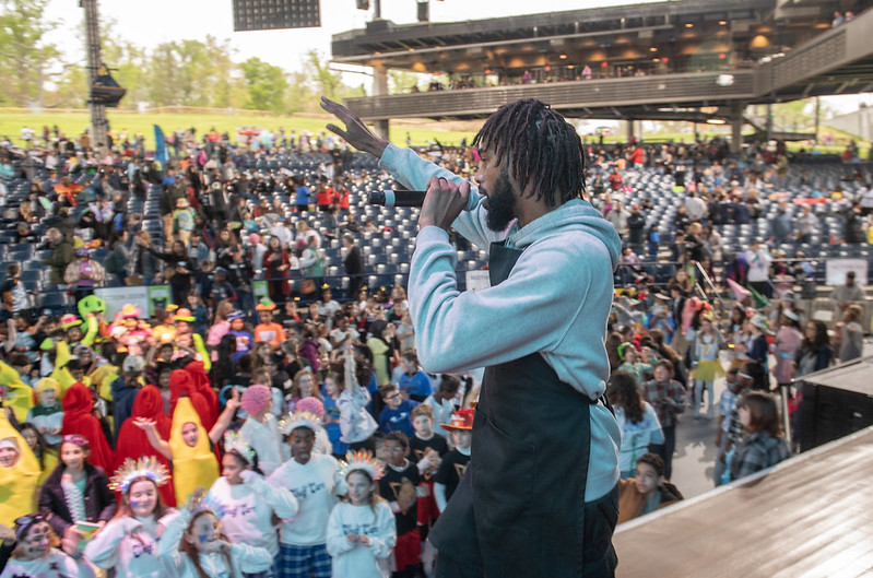DJ holding microphone and kids dancing.