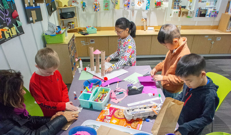 A group of children doing arts and crafts on a table