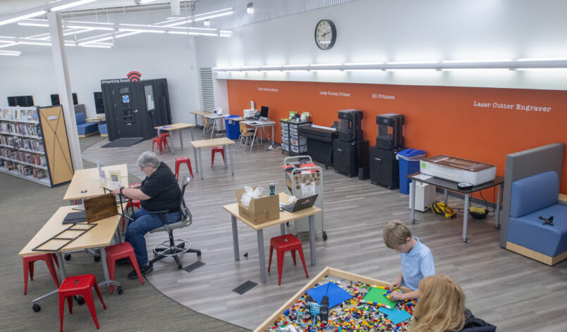 Howard County Library Systems Glenwood Makerspace with families creating DIY projects on the Lazer engraver 3D printers and lego table.