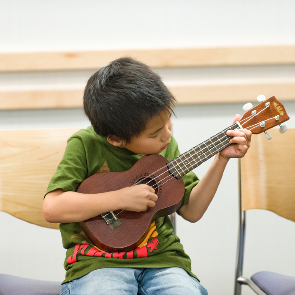 Child learning to play the Ukulele.